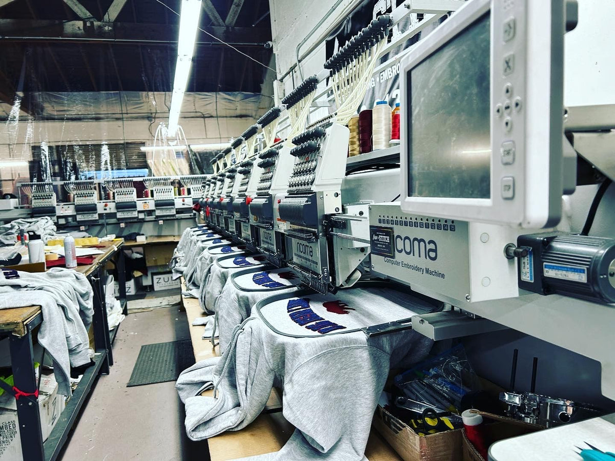 Hoodies positioned on an embroidery machine.